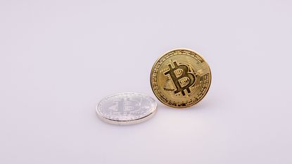 A golden Bitcoin sits against a lavender background.