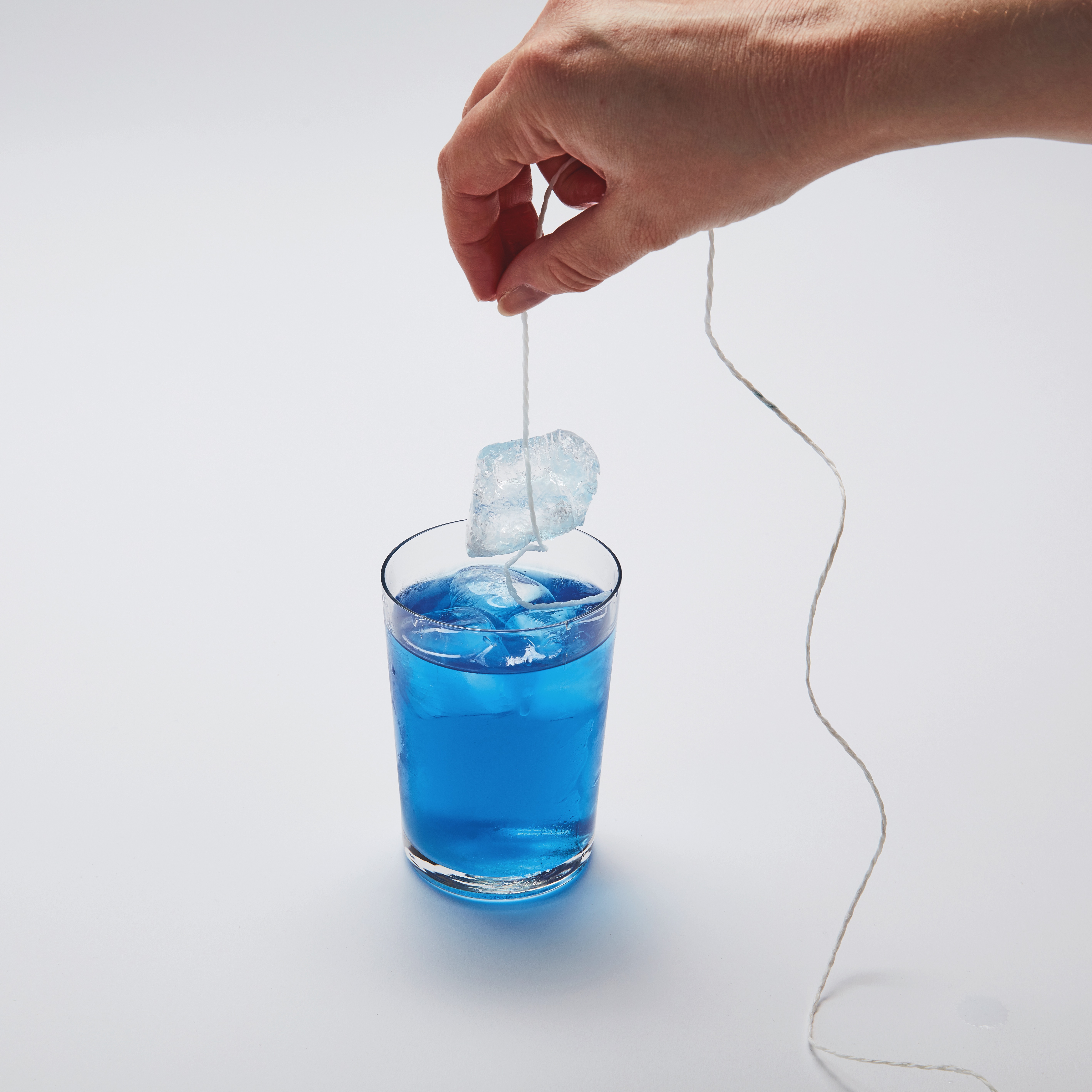 Fishing ice from a glass of water