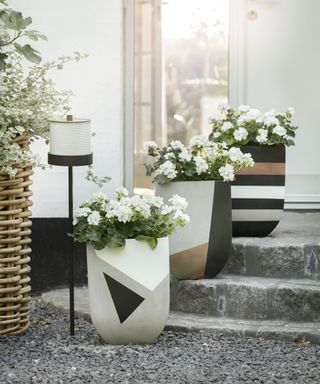 Large concrete planters painted up with bold geometric shapes