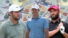 (L to R) Scottie Scheffler, Rory McIlroy and Jon Rahm cut out onto a background of 100 US dollar notes