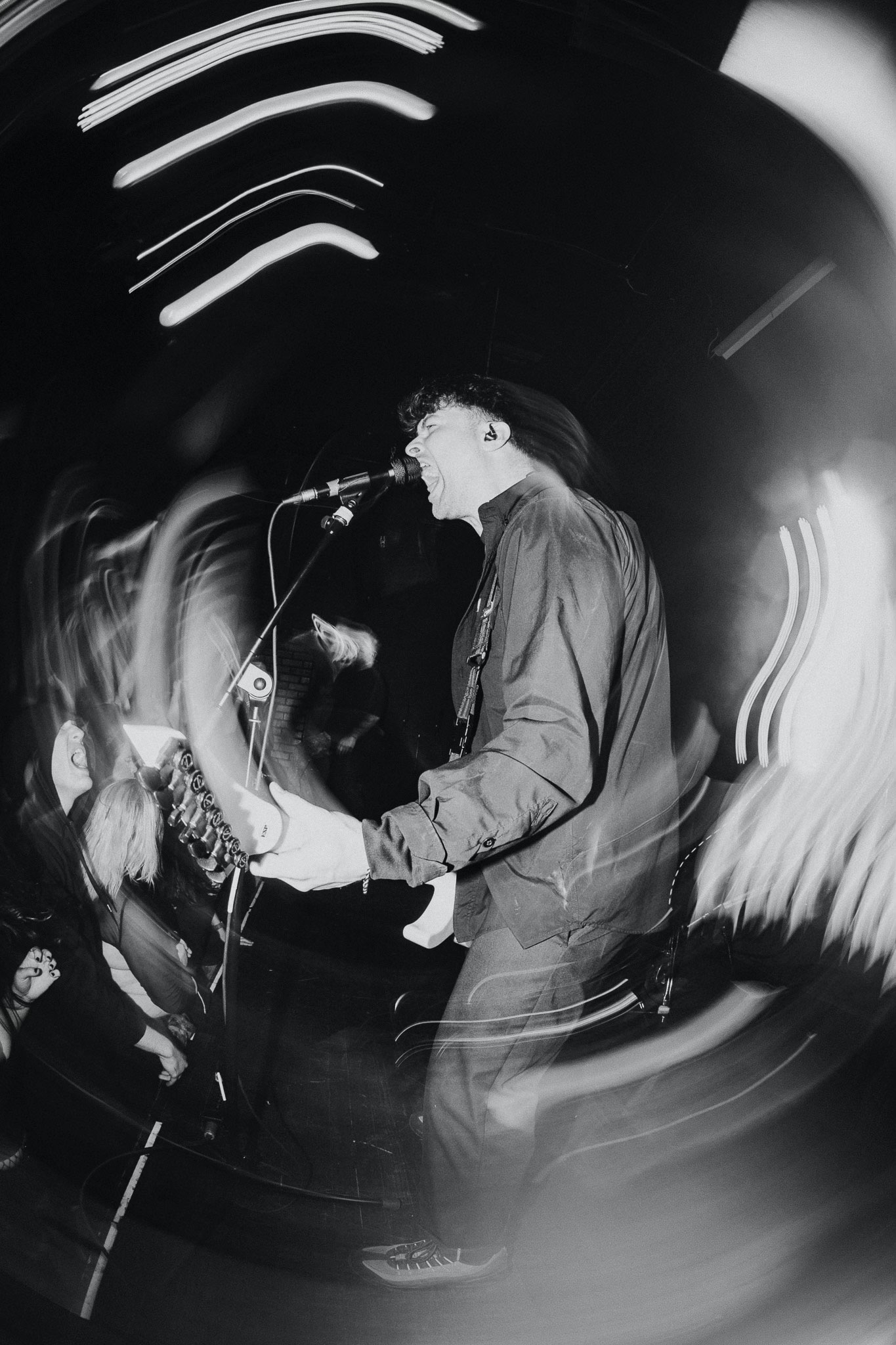 Black and white image of Varials guitarist Shane Lyons playing onstage