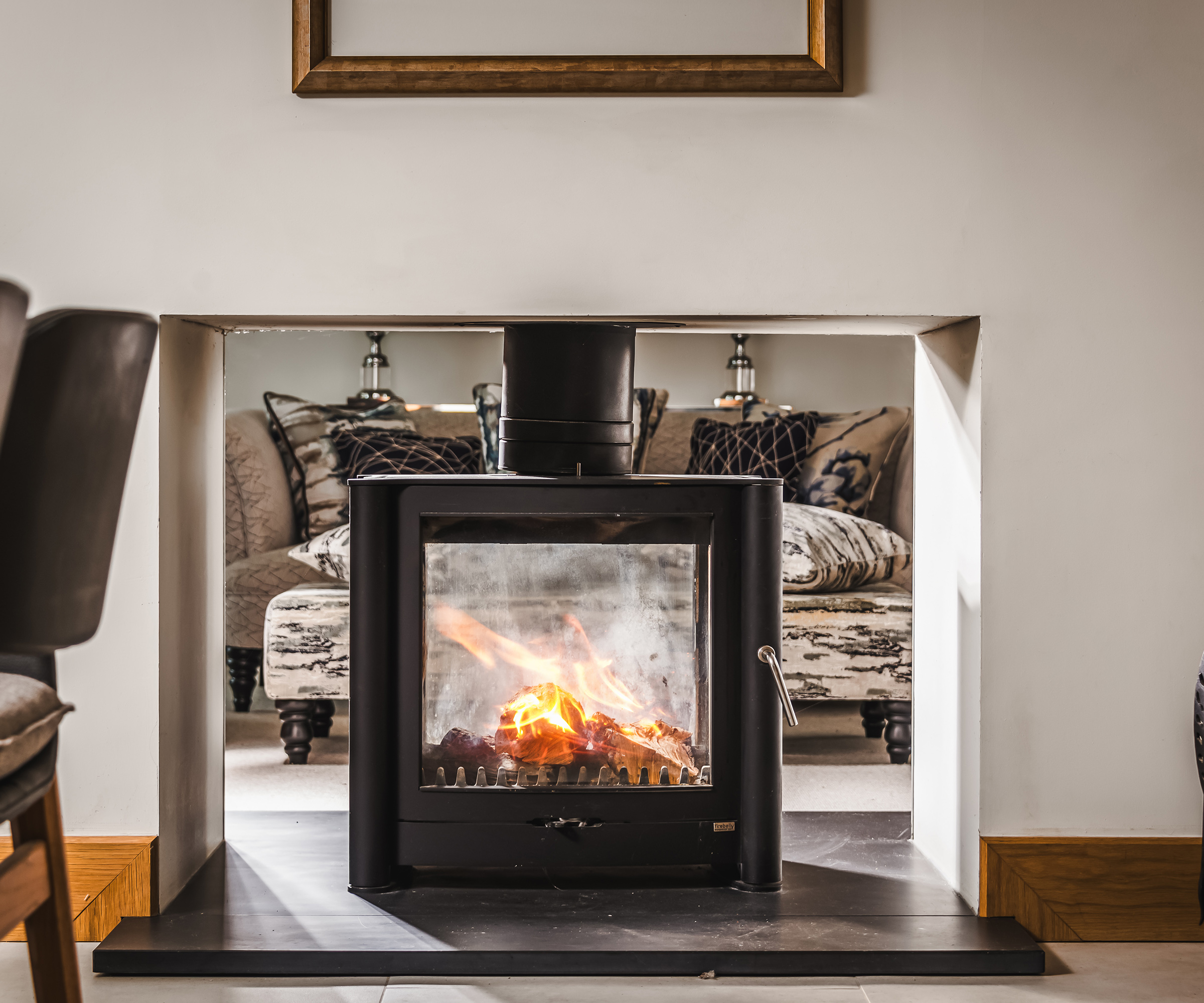 Log burning stove heating two rooms through a central wall