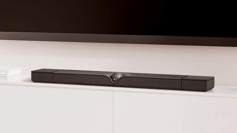 Devialet Dione on white TV bench with wall-mounted TV above
