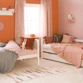 Orange bedroom with sheer curtains, feature wall and two white beds