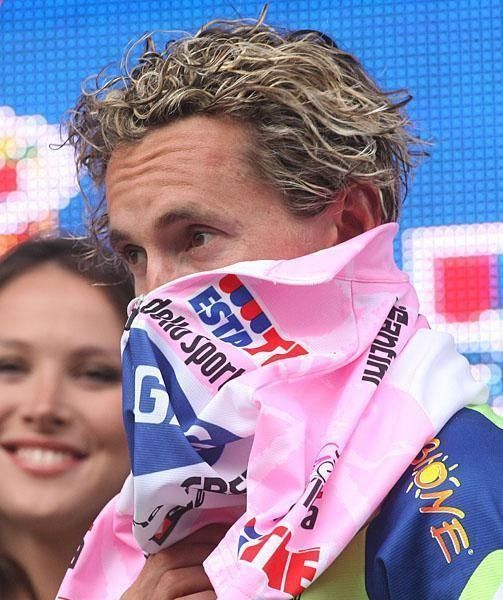 Pellizotti fits the pink jersey over his nose.