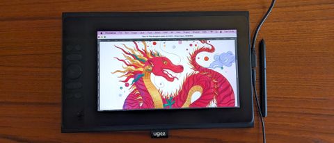Ugee UE12 Plus review; a drawing tablet on a wooden table with a dragon illustration