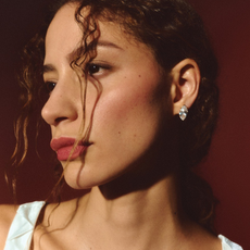 Photo of model wearing diamond stud earrings.