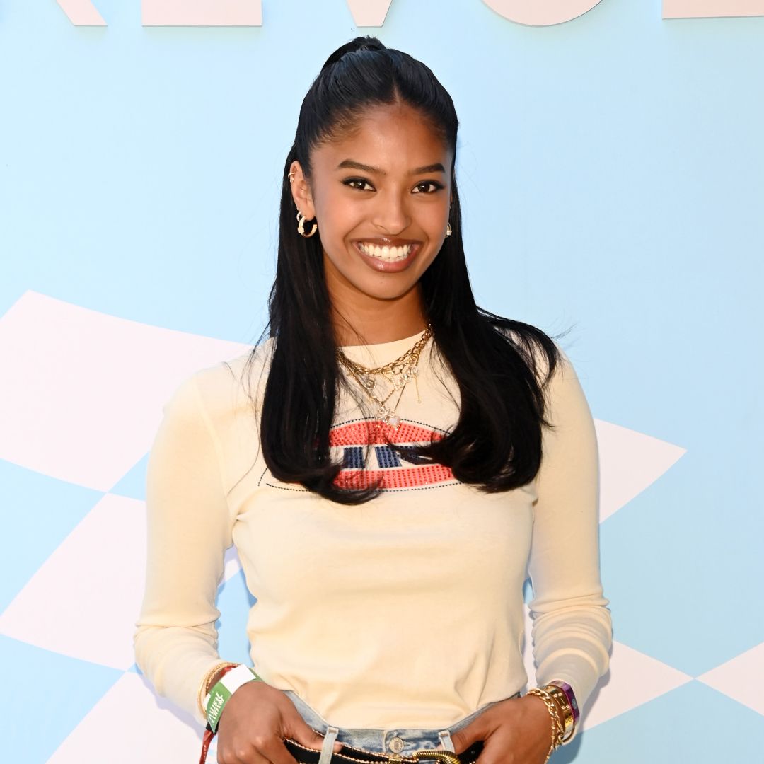 Natalia Bryant with a half up half down hairstyle, smiling at the camera. 