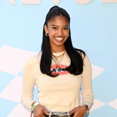 Natalia Bryant with a half up half down hairstyle, smiling at the camera.