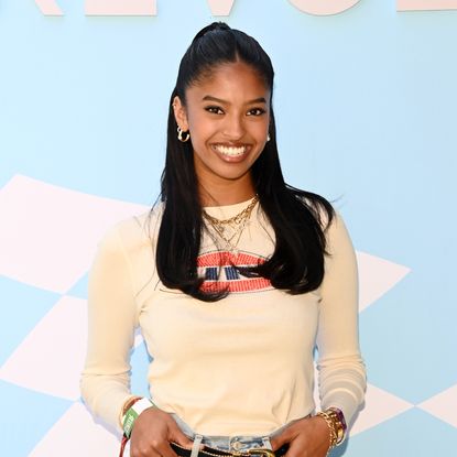 Natalia Bryant with a half up half down hairstyle, smiling at the camera. 