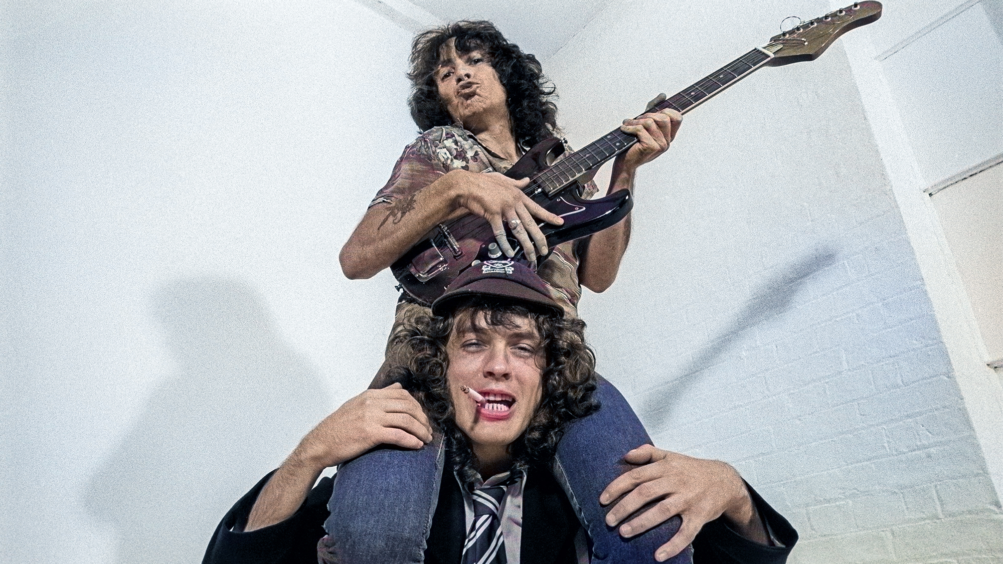 Bon Scott sitting on Angus Young's shoulders, August 1979
