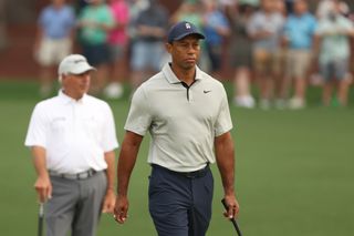 Tiger Woods walks down the fairway whilst Freddie Couples watches on