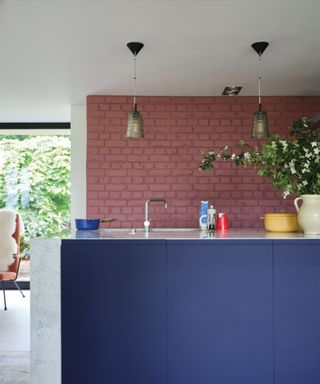 modern kitchen with plaster pink brick wall, violet blue kitchen island