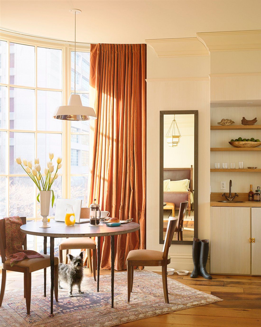 A modernism-inspired hotel features huge spaces letting plenty of natural light in, wooden and leather furnishings, wall art, and an earthy palette throughout its building.