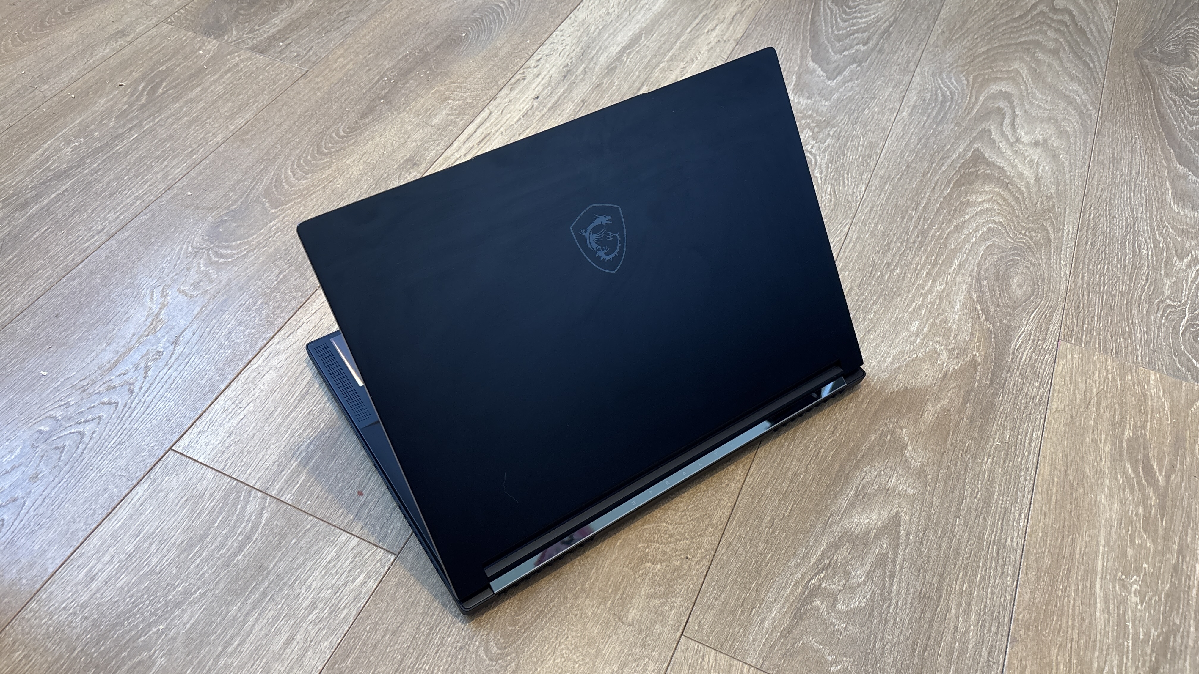 MSI Stealth A16 AI+ on wooden surface