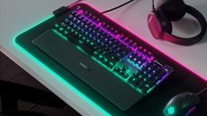 SteelSeries Apex 5 mechanical keyboard shown on desk with RGB lighting turned on