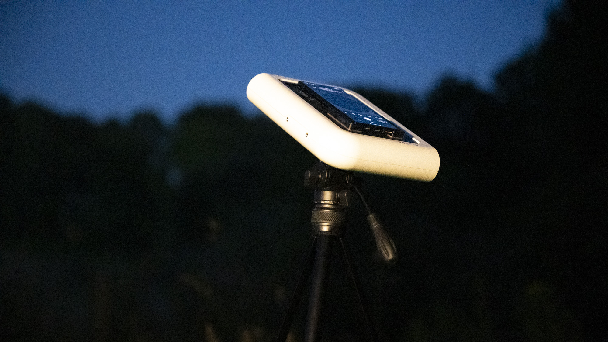 Vaonis Hestia smart telescope on a tripod pointing up at the night sky with a Google Pixel phone attached