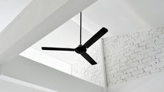 A black ceiling fan on a white brick pitched roof