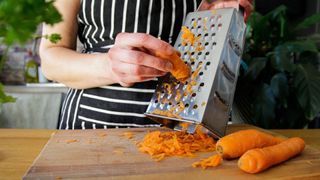 A grating tower being used to grate carrots