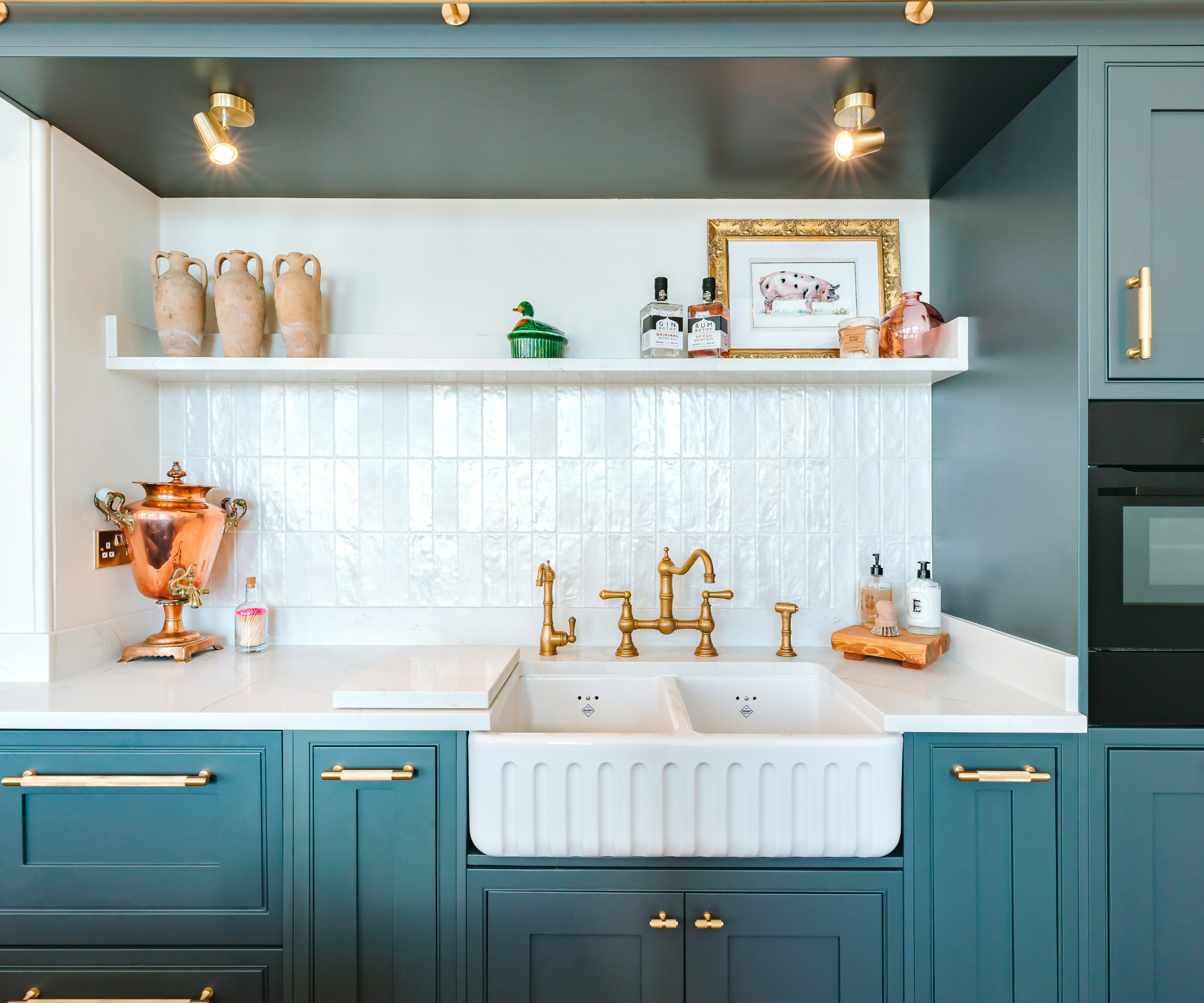 Blue kitchen with white tiles and spotlights above