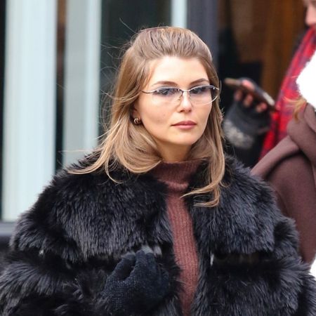 Olivia Jade wearing a black fur coat, brown turtleneck, jeans, a structured frame bag, and black block-heel ankle boots