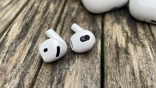 Apple AirPods 4 and AirPods 3 lying side by side on table