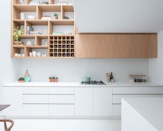 Modern kitchen design featuring a galley layout in a sleek white scheme with wooden open shelving.