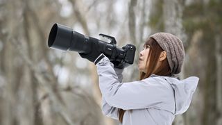 Photographer with the Nikkor Z 180-600mm lens in the hand outdoors wintry location