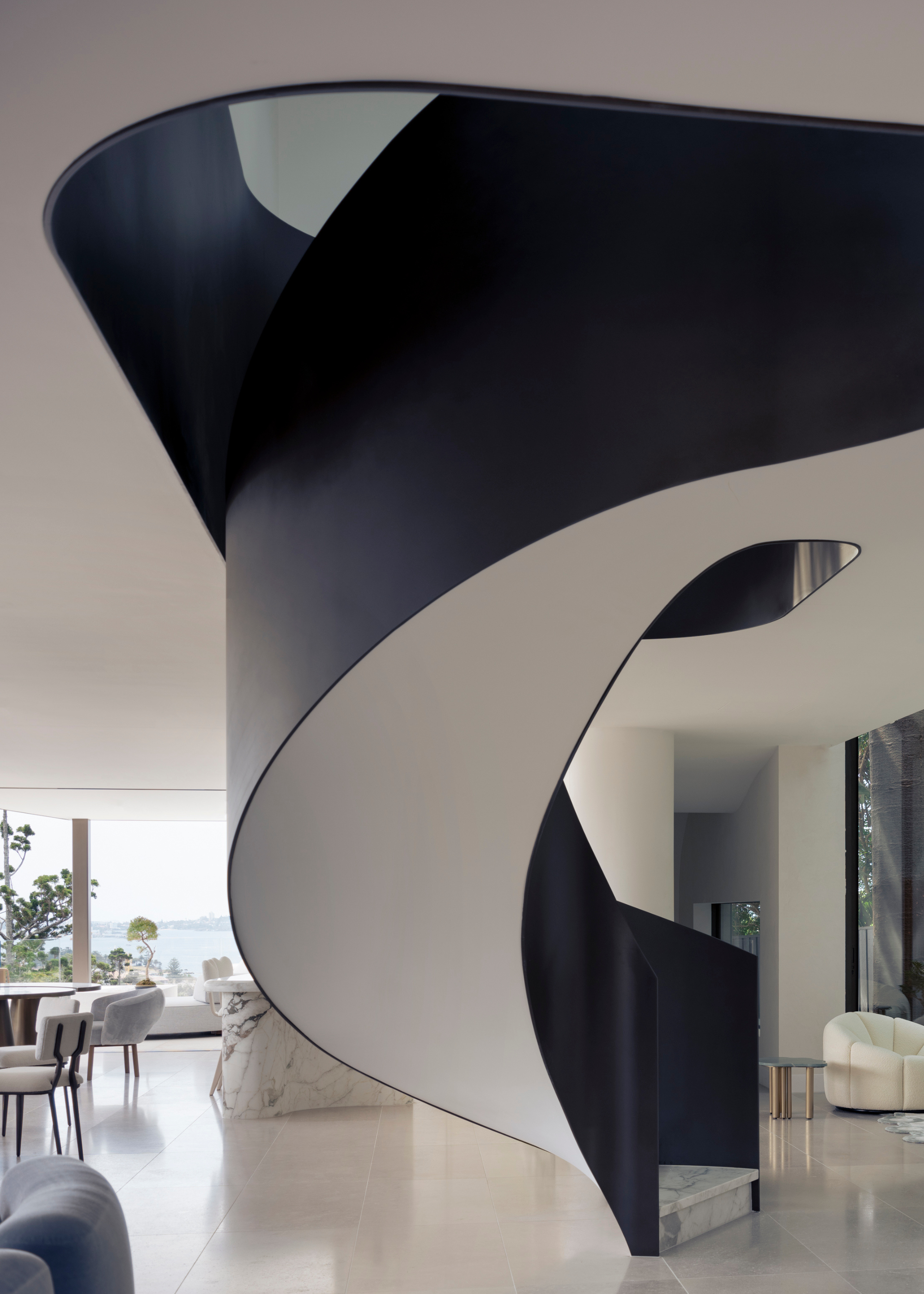 A curved black and white curved staircase in a living room