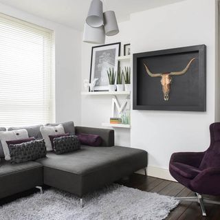 living room with white wall and grey couch