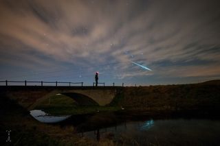 A Geminid meteor streaks across the night sky above a skywatcher in Hungary, on Dec. 11, 2014. 