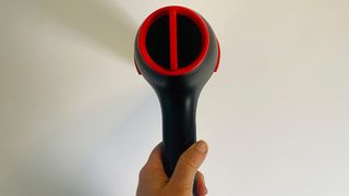 A hand holding the Revlon SmoothStay Coconut-Oil Infused Hair Dryer to show the removable end cap