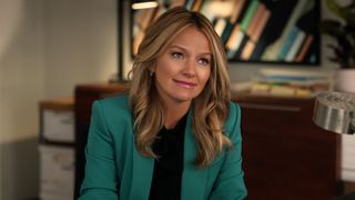 Becki Newton as Lorna sitting at a desk in The Lincoln Lawyer season 2