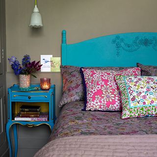 bedroom with turquoise headboard and floral pillows