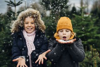 Brother and sister having fun with snow before Christmas