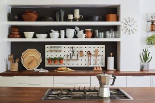 Pegboard is used in a white kitchen as a handy kitchen storage idea