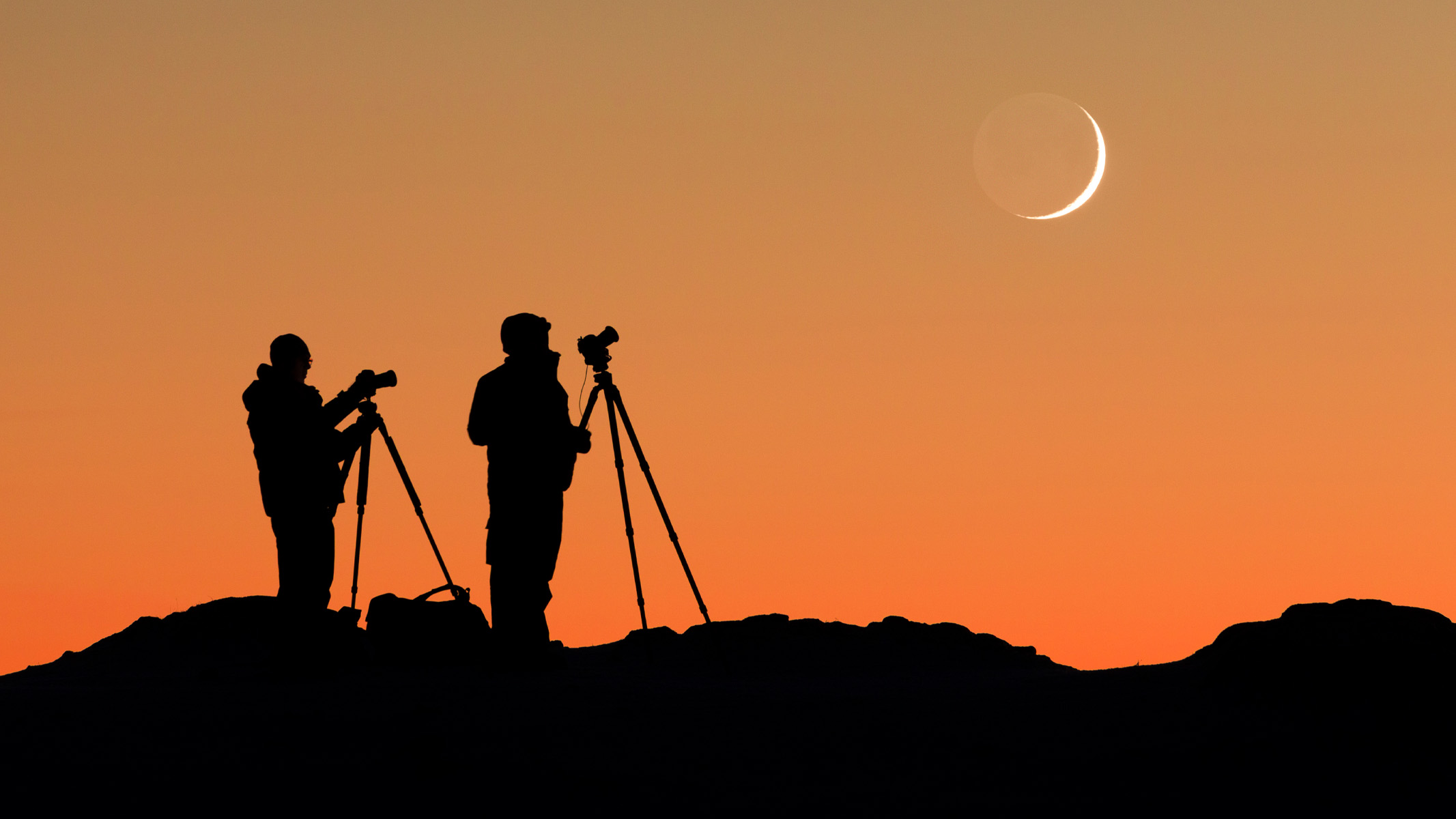 two people photographing the moon