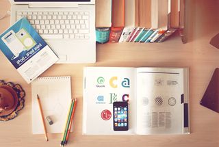 desk with books, phones and notepads focusing on marketing