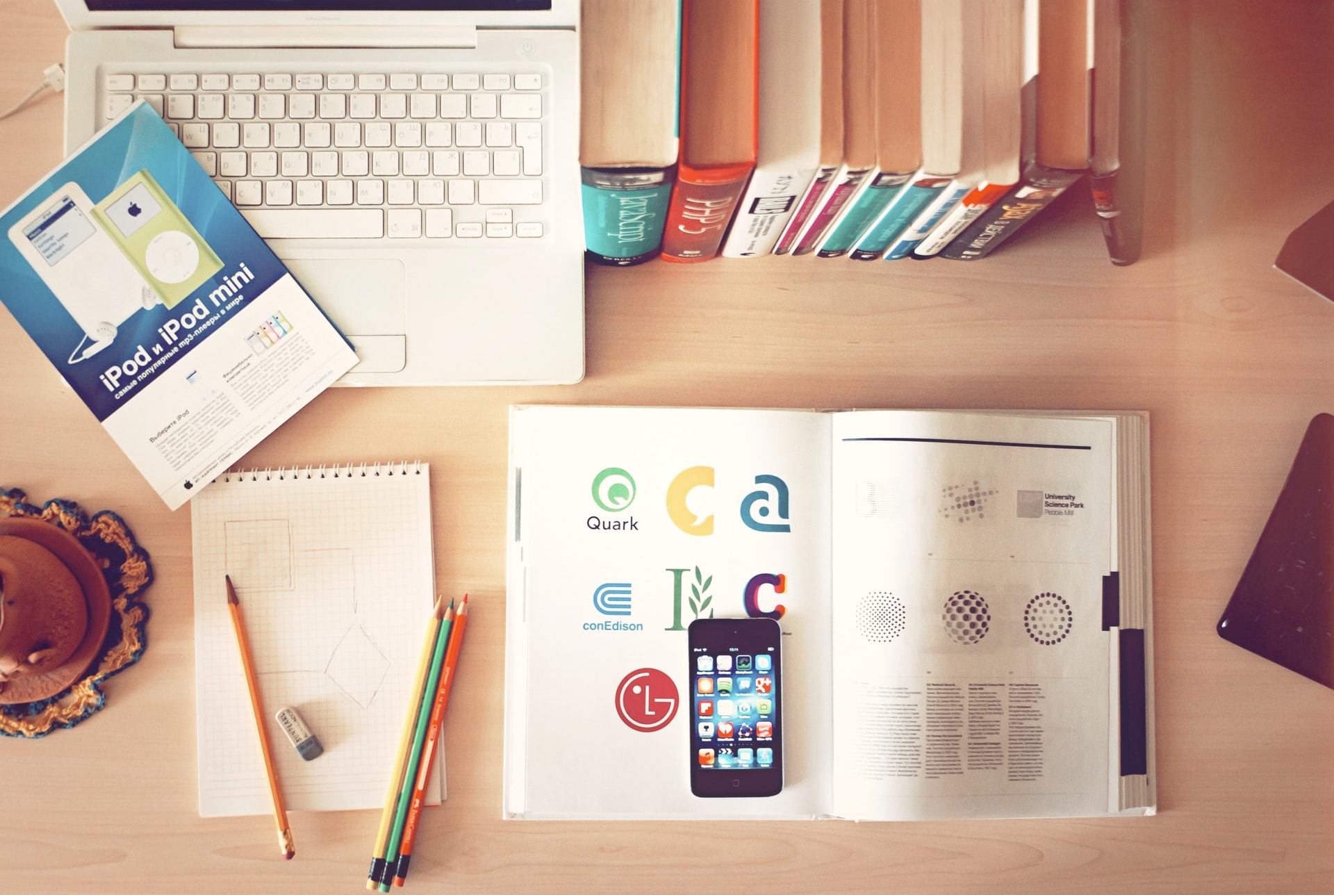 meja dengan buku, telepon, dan buku catatan yang berfokus pada pemasaran