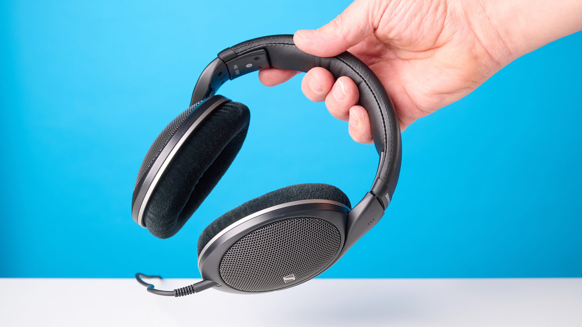 The Sennheiser HD 550 headphones on a stone surface with a blue background