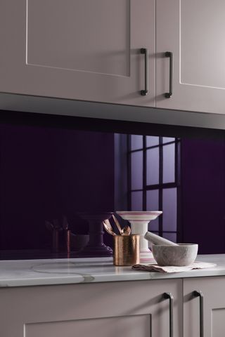 pink kitchen cabinets with purple splash back