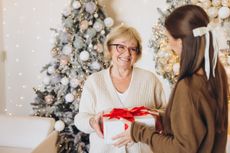Joyful Holiday Gift Exchange Between Grandmother and Granddaughter