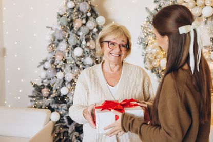 Joyful Holiday Gift Exchange Between Grandmother and Granddaughter