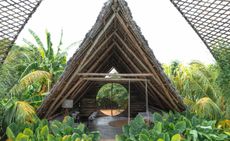 A triangle cabana-style hotel room made of natural materials