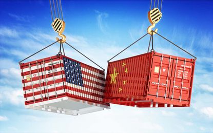 Freight transportation concept, cargo containers with USA and China flags hoisted by crane hooks on blue cloudy sky background