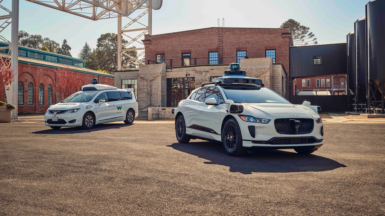 Waymo's legacy car beside its more current model.