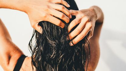 woman combing fingers through her hair