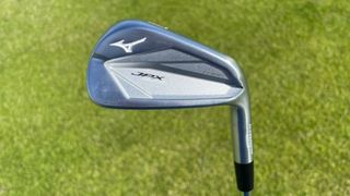 The stunning players Mizuno JPX923 Tour Iron showing off its stainless steel cavity back