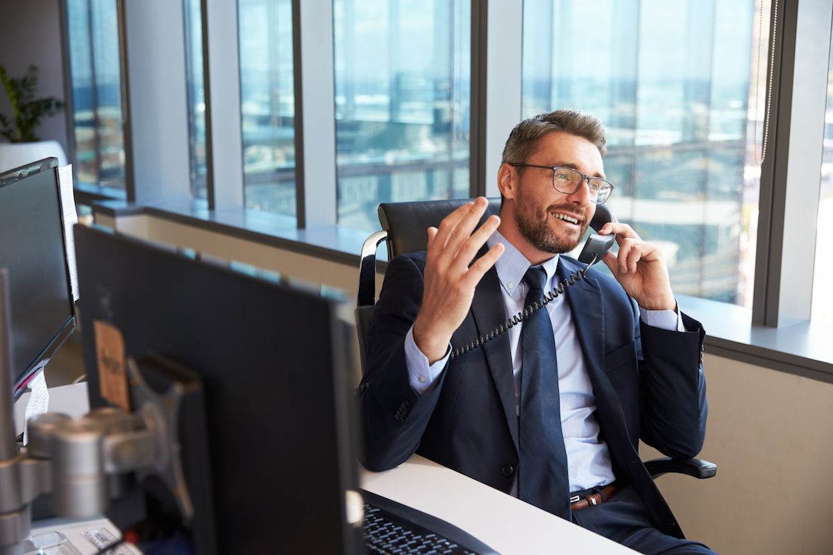 Man in a suit on the phone at his desk