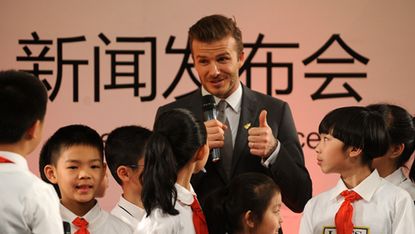 Football superstar David Beckham (C) answers questions from a group of pupils during a press conference at a primary school in Beijing on March 20.Beckham flew to Beijing on March 20 to take 
